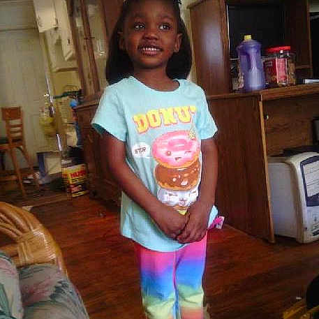Camoniee joined the competition — help win amazing prizes! child, smiling, indoors, colorful_clothing, donut_graphic, rainbow_pants, standing, wooden_floor, furniture, living_room, cabinet, sneakers, hair_bow, happy, person, portrait, home, casual, young_girl, cute