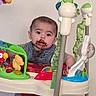 Robin joined the competition — help win amazing prizes! baby, child, messy_face, chocolate, activity_jumper, toys, indoor, carpet, playtime, colorful, curious, standing, infant, clothing, green, red, plastic, fun, cute, person