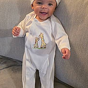 Ayla joined the competition — help win amazing prizes! baby, child, couch, cozy, cute, fabric, face, feet, footed_pajamas, giraffe_print, happy, hat, home, indoor, infant, onesie, person, smile, standing, white_clothing