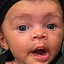 baby, close_up, face, headband, black_clothing, expression, wide_eyes, mouth_open, infant, cute, child, skin, person, portrait, young, curious, headwear, indoors, human, newborn