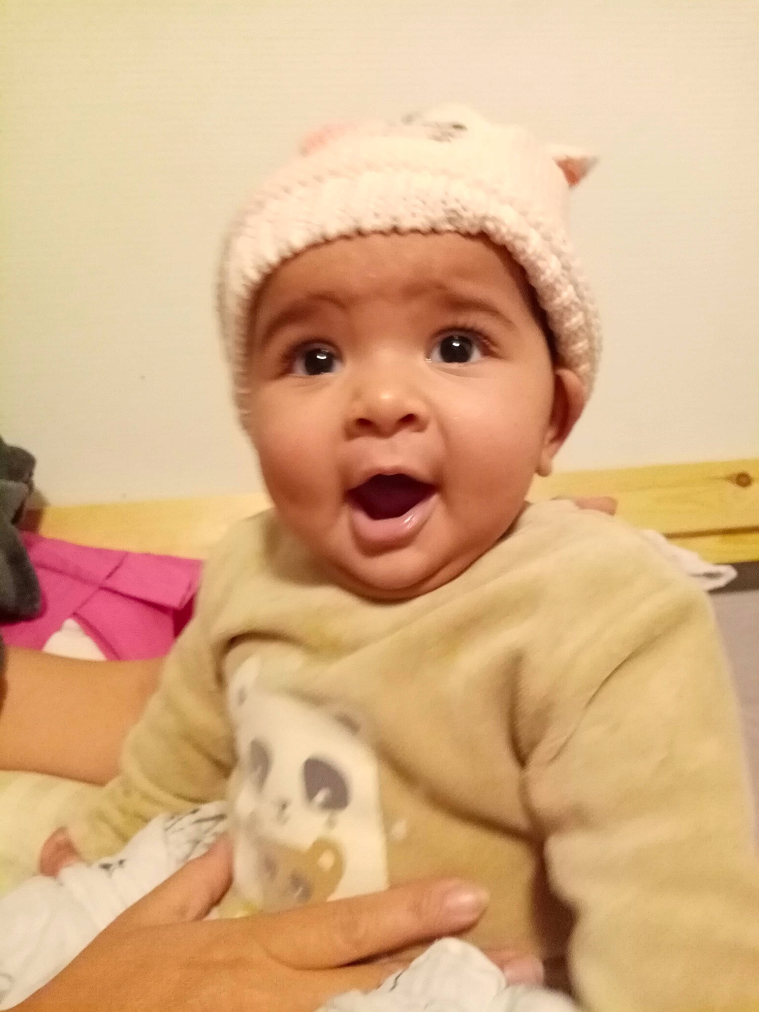 Ilona a rejoint le concours — aidez-le/la à gagner de superbes lots ! baby, baby_laughing, baby_toddler_clothing, beanie, bonnet, cheek, child, costume_accessory, finger, hand, headwear, knit_cap, nail, person, skin, surprise, sweater, toddler