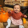 baby, child, smiling, happy, pumpkin, pumpkin_patch, autumn, fall, hay_bale, barrel, rustic, outdoor, portrait, sitting, reaching, dress, sweater, white_socks, hair_bows, farm_scene