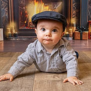 Lizio participe au concours pour gagner de l'argent avec cette photo : baby, child, crawling, hat, striped_shirt, floor, wooden_floor, fireplace, presents, gift_boxes, warm_lighting, indoors, holiday, cute, portrait, young_child, expression, home, cozy, decor