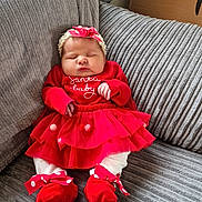 Flori is registered to the contest to win money with this photo: baby, infant, sleeping, red_clothing, headband, polka_dot, couch, gray_couch, soft_texture, festive, holiday, tutu_skirt, baby_shoes, white_tights, indoors, cute, peaceful, child, portrait, cozy