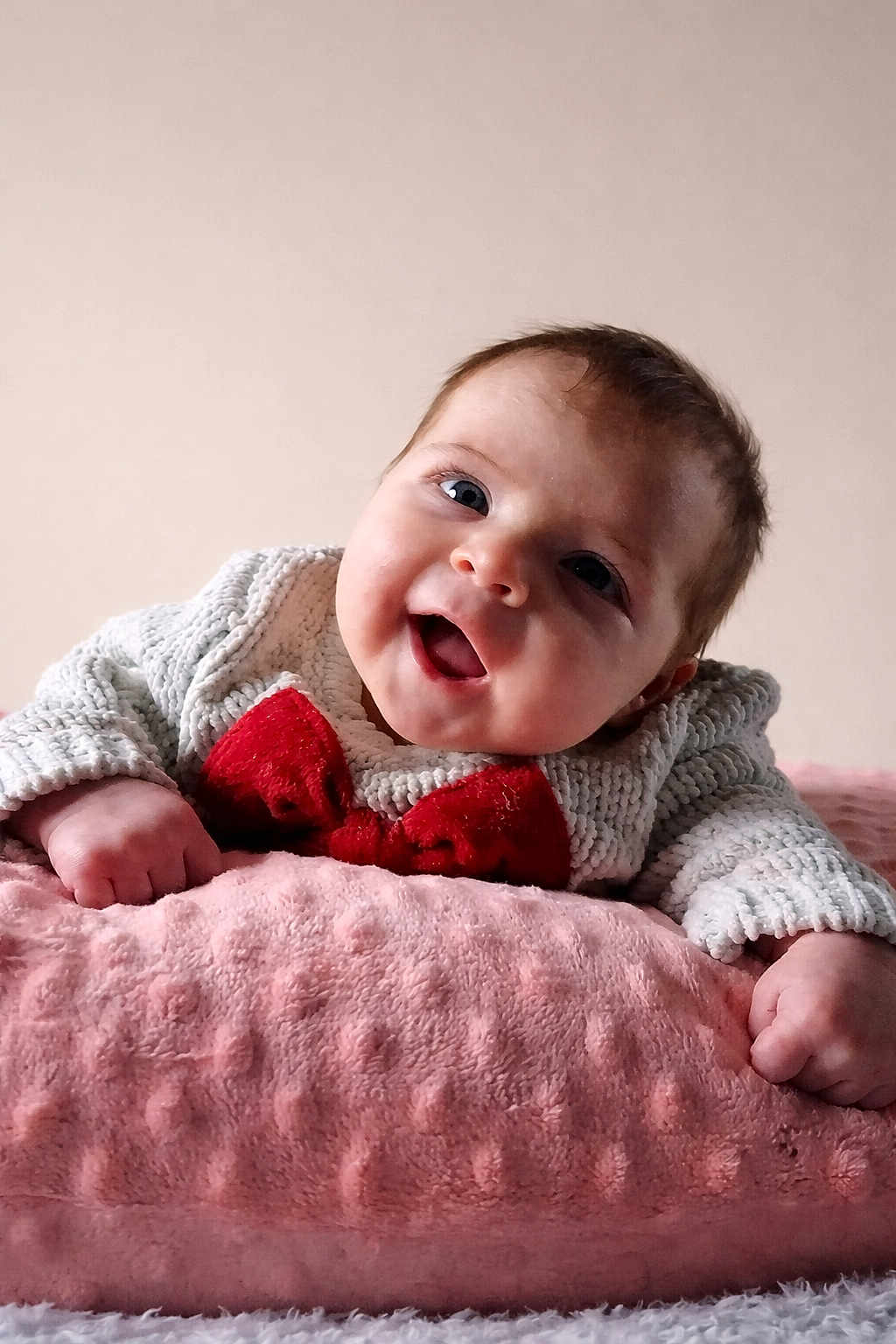 Flori joined the competition — help win amazing prizes! baby, smiling, happy, infant, blanket, knitted_sweater, red_bow, cute, portrait, child, soft_texture, pink, cozy, face, young_child, indoors, person, closeup, expression, cheerful