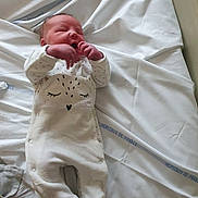 David participe au concours pour gagner de l'argent avec cette photo : newborn, baby, infant, hospital, bed, white_onesie, sleeping, hands, face, cute, lying_down, fabric, sheet, hospital_bed, child, footed_pajamas, soft, peaceful, indoors, person