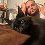Marlin is registered to the contest to win money with this photo: adult, animal, beard, blackcat, cat, clothing, couch, face, furniture, head, kitten, male, man, manx, person, pet, photography, portrait, undershirt, wood