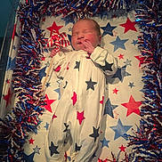 Skyler joined the competition — help win amazing prizes! newborn, baby, crib, onesie, stars, red, white, blue, pinwheel, garland, sleeping, infant, pattern, decor, celebration, holiday, cute, face, hand, footed_pajamas