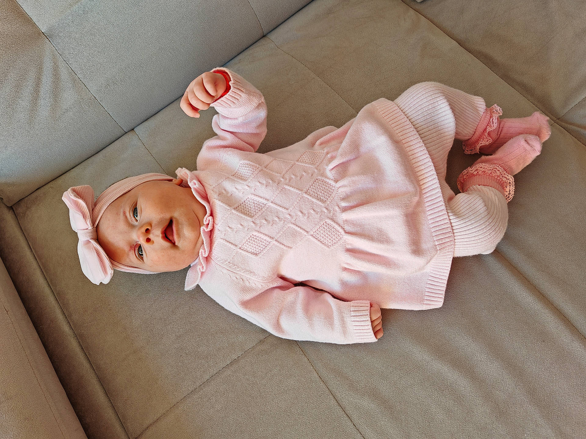 Smilte is registered to the contest to win money with this photo: baby, bodypart, bonnet, cap, clothing, couch, face, finger, furniture, glove, hand, hat, head, hood, hoodie, knitwear, newborn, person, sweater, sweatshirt