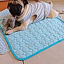 pug, dog, pet, indoor, quilted_mat, stuffed_toy, elephant_toy, white_vest, tile_floor, chair, bag, plush_toys, animal, cute, lying_down, paw, floor, cozy, home, relaxed