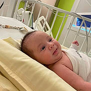 Ethan participe au concours pour gagner de l'argent avec cette photo : baby, infant, newborn, crib, pillow, blanket, smile, eyes, hair, cheeks, bedding, hospital_monitor, medical_equipment, crib_rail, pacifier_clip, gaze, portrait, cute, skin, laying