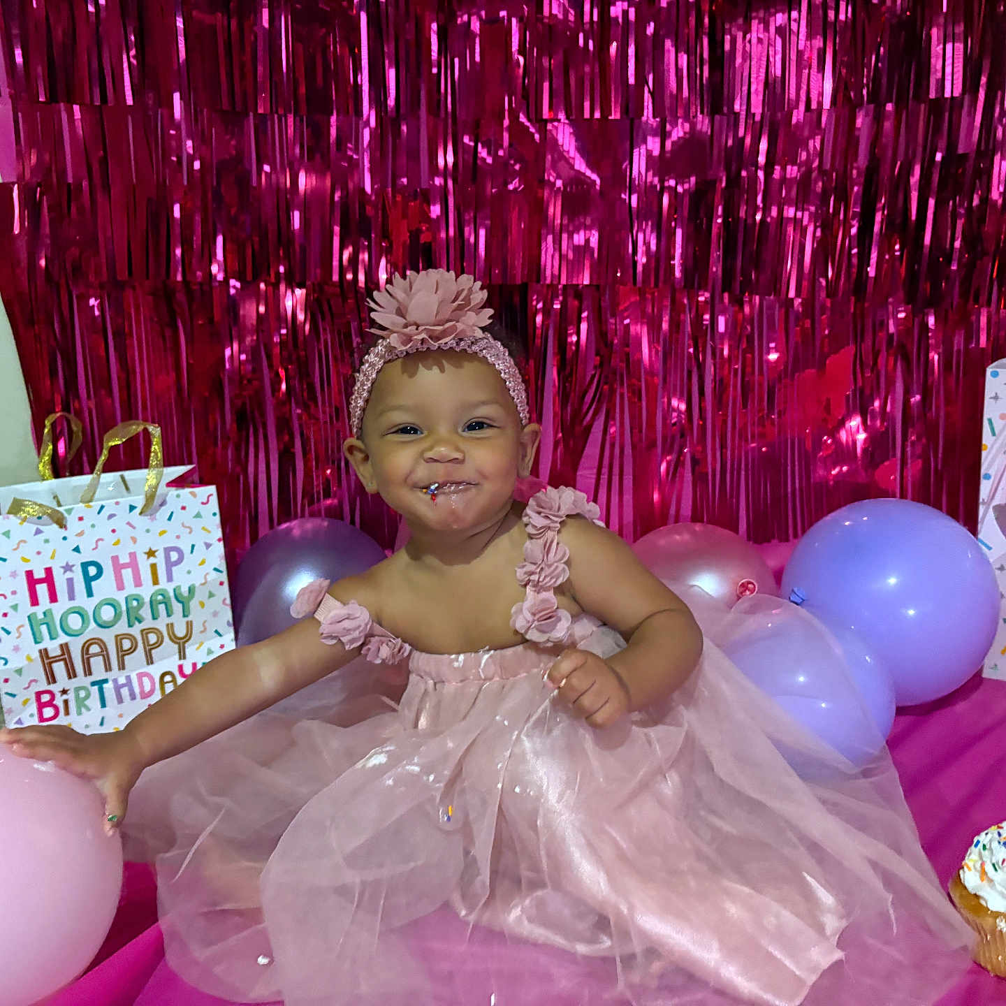 Nora joined the competition — help win amazing prizes! baby, balloon, birthday, cake, celebration, child, cupcake, decorations, floor, fun, gift_bag, happy, headband, indoors, party, pink_dress, smile, sprinkles, toddler, wall