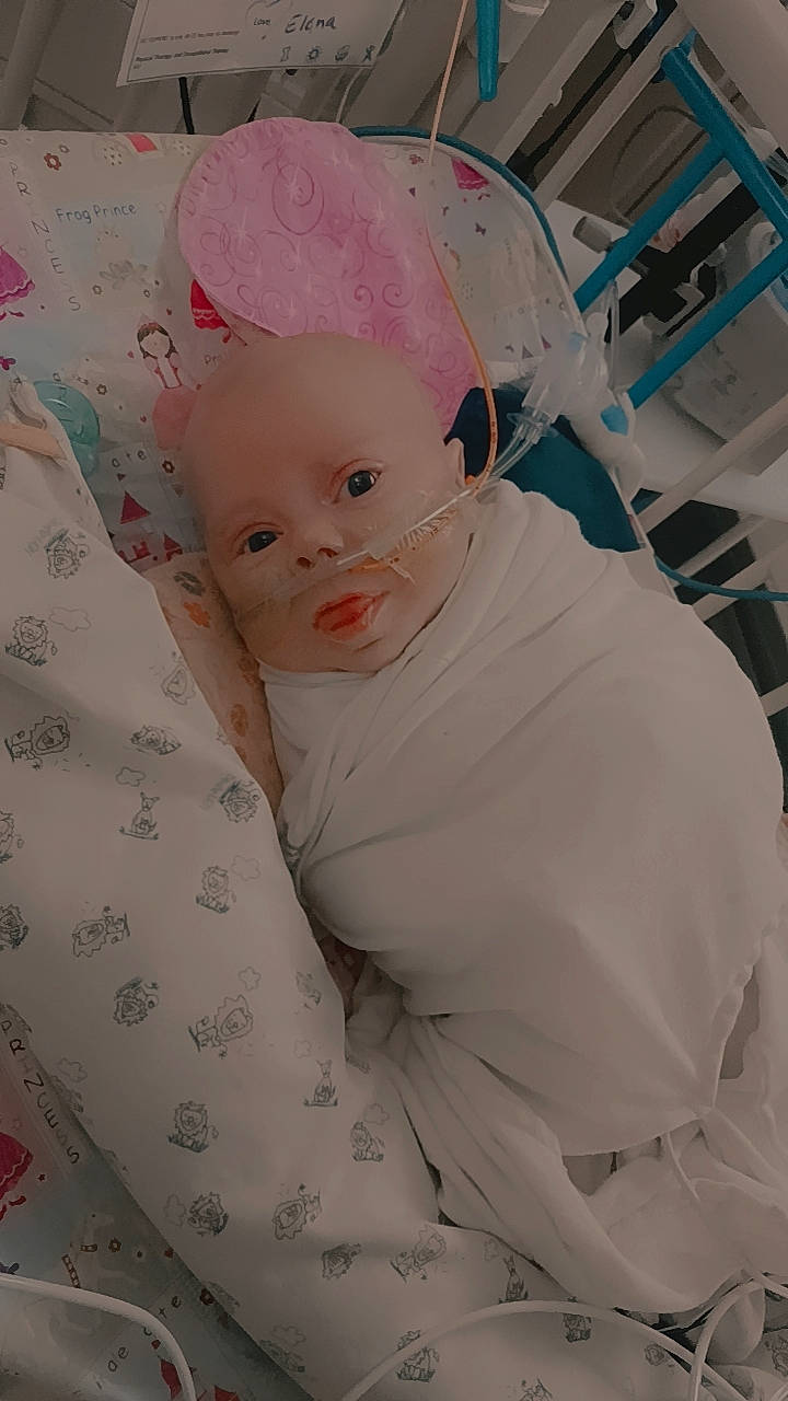 Elana joined the competition — help win amazing prizes! baby, baby_products, baby_toddler_clothing, cap, cheek, child, comfort, costume, costume_hat, fashion_accessory, fun, happy, headband, headpiece, linens, magenta, person, pink, room, sitting