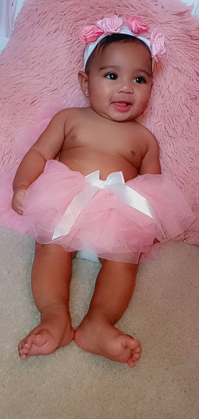 Arielle is registered to the contest to win money with this photo: arm, baby, baby_toddler_clothing, cheek, dress, finger, flash_photography, happy, human_body, human_leg, iris, leg, lip, person, pink, skin, sleeve, smile, thigh, toddler