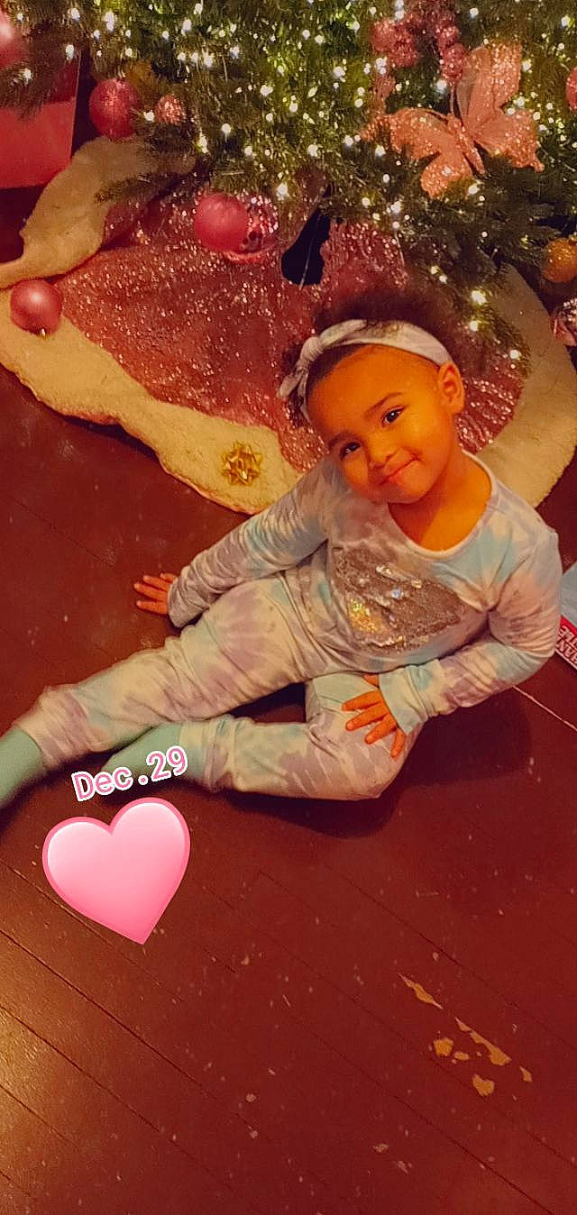 Aliyanna is registered to the contest to win money with this photo: baby, baby_toddler_clothing, child, christmas_tree, comfort_food, event, flooring, fun, happy, holiday, joy, ornament, peach, person, pink, sitting, sock, toddler, wood