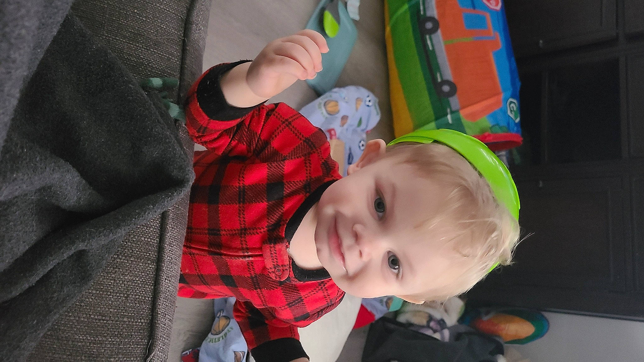 Layton is registered to the contest to win money with this photo: baby, baby_products, baby_toddler_clothing, child, event, fictional_character, fun, happy, joy, leisure, pattern, person, personal_protective_equipment, plaid, play, sitting, smile, tartan, textile, toddler