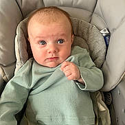 Rogan is registered to the contest to win money with this photo: baby, blue_eyes, car_seat, chicco, child, clothing, comfortable, cute, expression, face, hand, indoor, infant, padded, portrait, seat, sitting, sleeves, soft_texture, young_child