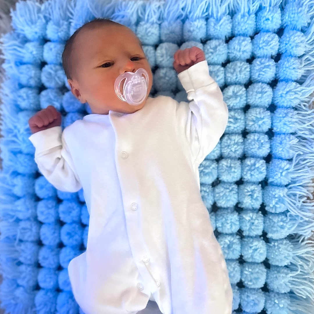 Rogan joined the competition — help win amazing prizes! baby, blanket, bodypart, bonnet, clothing, crib, cushion, face, finger, furniture, hand, hat, head, homedecor, newborn, person, photography, portrait, sleeping, yawning