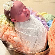 Layla is registered to the contest to win money with this photo: baby, blanket, child, colorful, cozy, cute, flower, headband, indoors, infant, knit, newborn, peaceful, portrait, resting, sleeping, soft, wooden_bowl, wrapped, yarn