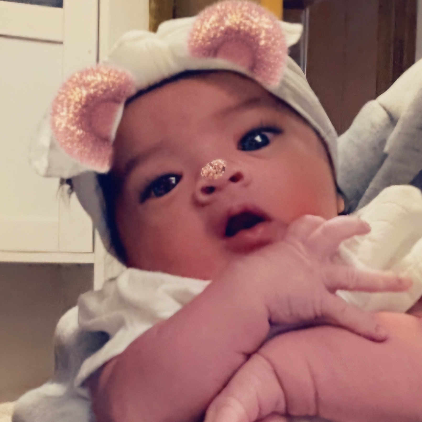 Desiree is registered to the contest to win money with this photo: architecture, baby, baseballcap, bodypart, bonnet, building, cap, clothing, face, finger, glove, hand, hat, head, hospital, indoors, newborn, person, photography, portrait