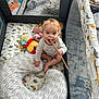 Oliver is registered to the contest to win money with this photo: baby, blond_hair, blue_eyes, child, colorful, curious, fabric, face, floor, happy, home, indoor, patterned, pillow, playpen, sitting, smiling, soft_toys, toy, wooden_stick