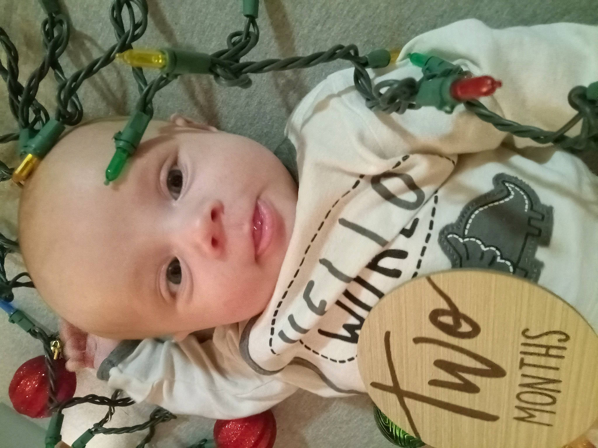 Silas is registered to the contest to win money with this photo: baby, baby_products, baby_toddler_clothing, cheek, child, collectable, eyelash, fashion_accessory, font, grass, happy, pattern, person, plant, room, toddler, tree, wood