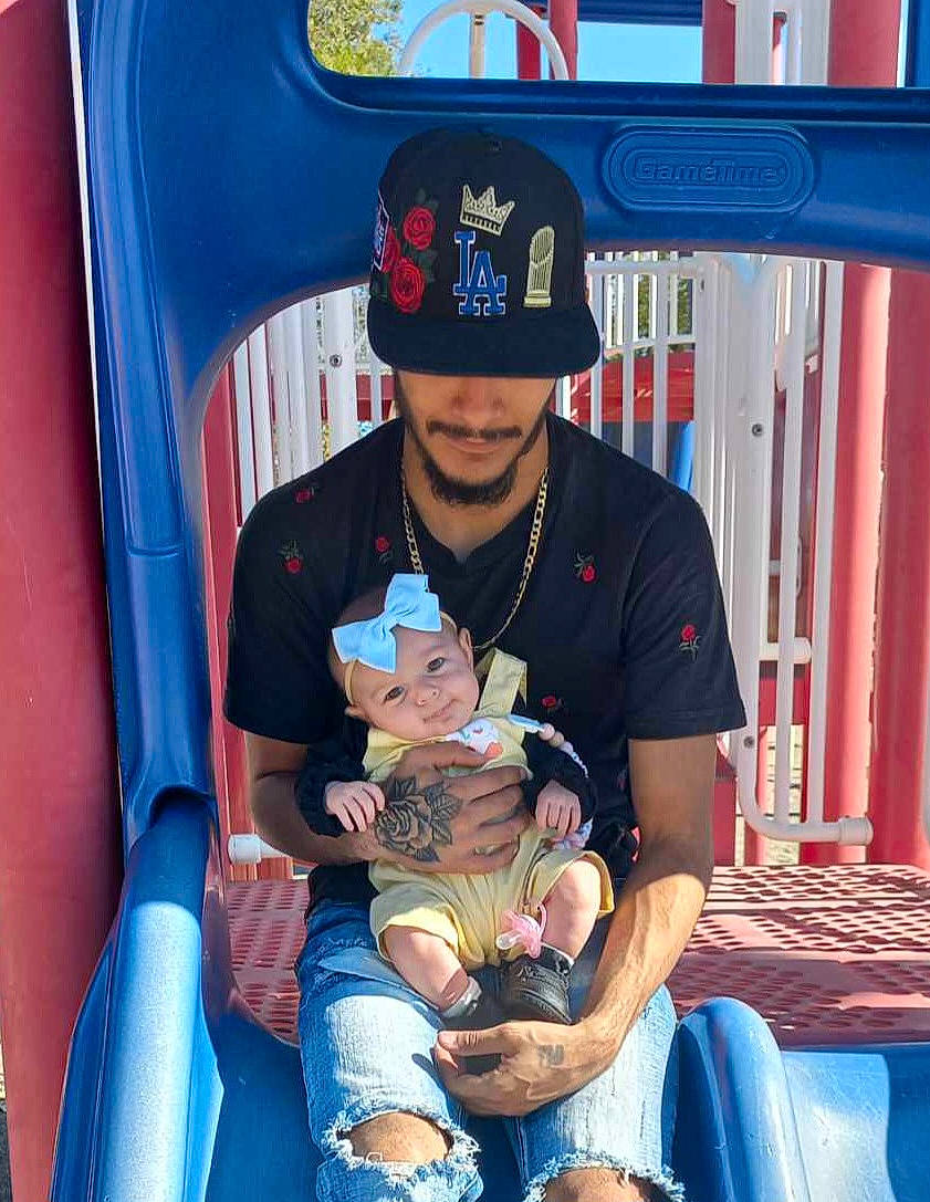 Emerald is registered to the contest to win money with this photo: baseball_cap, blue, cap, child, electric_blue, eyewear, fun, hat, headwear, lap, leisure, person, personal_protective_equipment, recreation, shorts, sitting, sun_hat, t_shirt, thigh, toddler