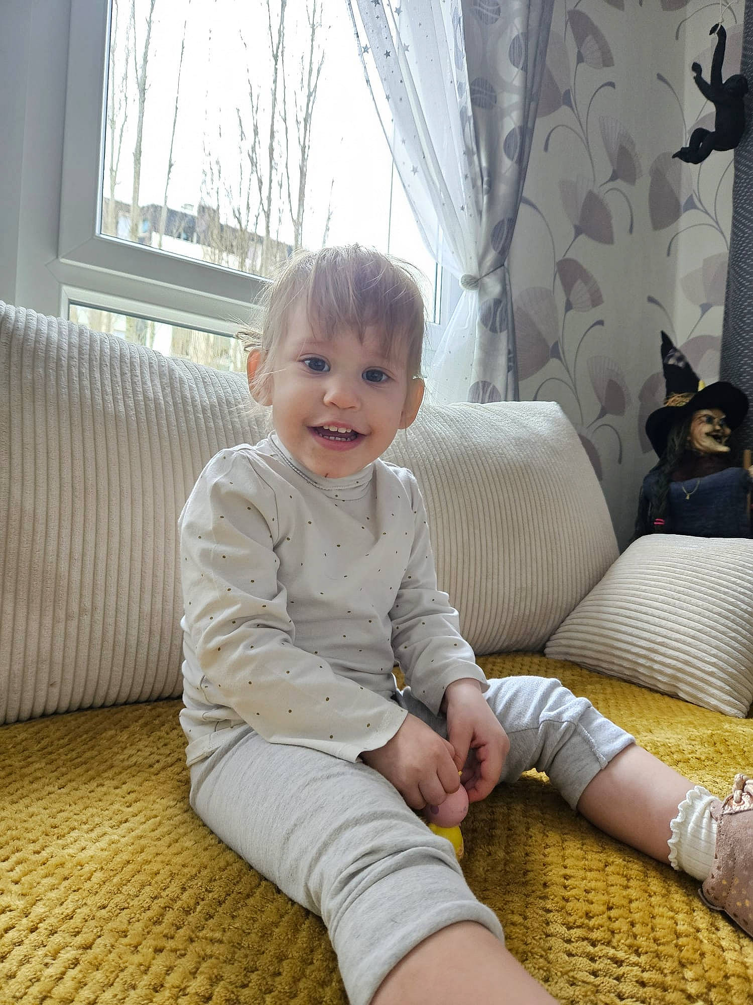 Rosana a rejoint le concours — aidez-le/la à gagner de superbes lots ! baby, baby_toddler_clothing, child, comfort, couch, curtain, eye, flooring, human_leg, joy, knee, lap, living_room, person, sitting, smile, sock, thigh, toddler, window