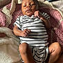 baby, infant, striped_clothing, crocheted_blanket, fist, onesie, bottle, denim_shorts, blanket, lying_down, person, skin, cute, newborn, cozy, indoor, soft_texture, sleepy, small_child, relaxed