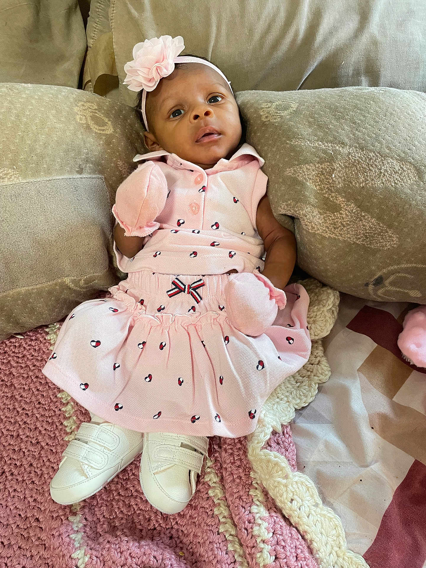 Nakiea joined the competition — help win amazing prizes! baby, infant, pink_dress, mittens, headband, flower, couch, pillows, knitted_blanket, white_shoes, indoor, portrait, cute, soft_texture, relaxed, looking_at_camera, small, child, cozy, comfortable