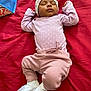 Nakiea is registered to the contest to win money with this photo: baby, sleeping, infant, pink_clothing, white_socks, hat, blanket, red_background, peaceful, cute, child, lying_down, soft_fabric, indoors, rest, adorable, small_person, cozy, portrait, nap