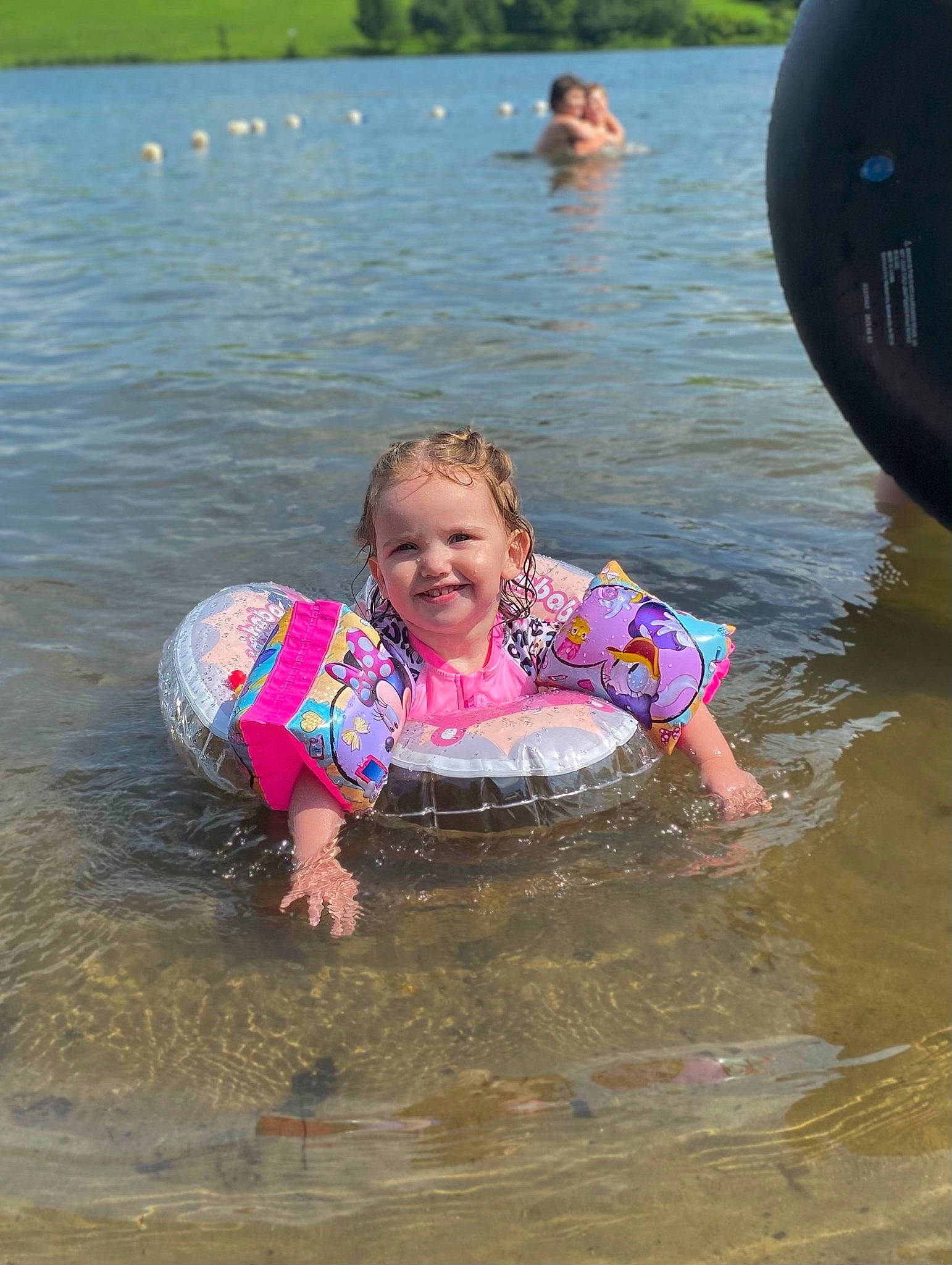 Thea Bean is registered to the contest to win money with this photo: baby_float, bathing, beauty, body_of_water, child, fun, happy, joy, lake, leisure, mammal, nature, outdoor_recreation, person, personal_protective_equipment, pink, recreation, smile, summer, toddler