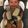 baby, car_seat, smiling, child, infant, mittens, seatbelt, safety_harness, happy, cute, indoor, clothing, portrait, young_child, seat, child_seat, baby_clothes, person, closeup, infant_face