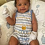 Armani is registered to the contest to win money with this photo: baby, infant, mittens, onesie, striped_clothing, smiling, face, cushion, elephant_print, balloon_print, pillow, cute, child, young, happy, indoors, portrait, sitting, person, apparel