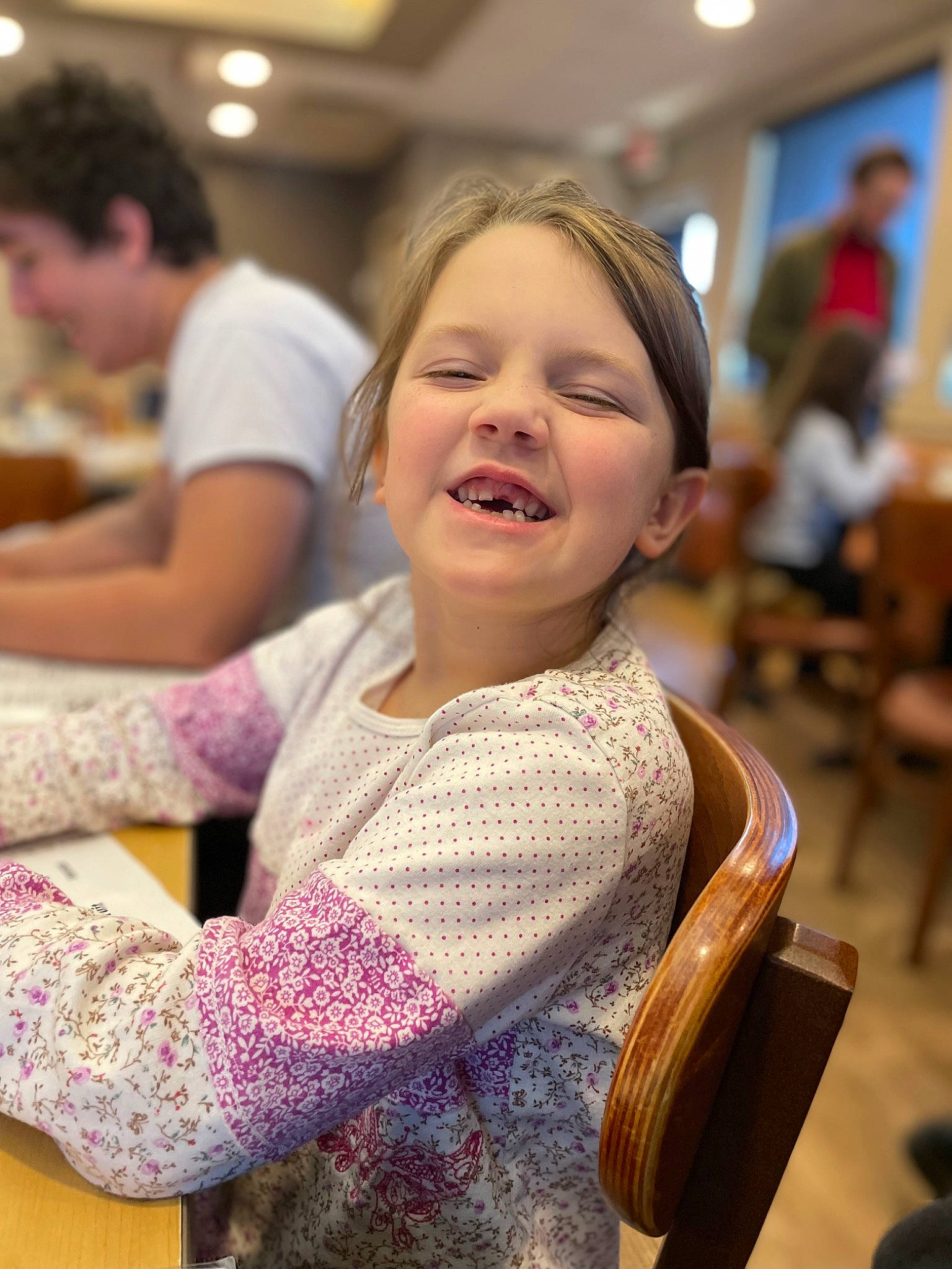 Vernyn is registered to the contest to win money with this photo: chair, child, event, facial_expression, flooring, fun, hair, hairstyle, happy, head, human, joy, leisure, person, recreation, room, sitting, smile, t_shirt, toddler