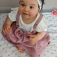 Chaïma participe au concours pour gagner de l'argent avec cette photo : adorable, baby, child, curious, cute, feet, flowers, hands, headband, indoor, infant, mattress, pink_dress, playful, portrait, sitting, smiling, soft_lighting, star_pattern, young_child