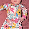 Maleia is registered to the contest to win money with this photo: baby, infant, child, portrait, lying_down, pink_blanket, floral_onesie, colorful_clothing, zipper, wide_eyes, brown_hair, face, hands, indoor, close_up, soft_background, textile, fashion, adorable, photography