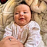 Maleia joined the competition — help win amazing prizes! baby, infant, child, smiling, portrait, indoors, blanket, bed, onesie, clothing, face, head, eyes, mouth, hand, adult_hand, ring, fluffy, cozy, happy
