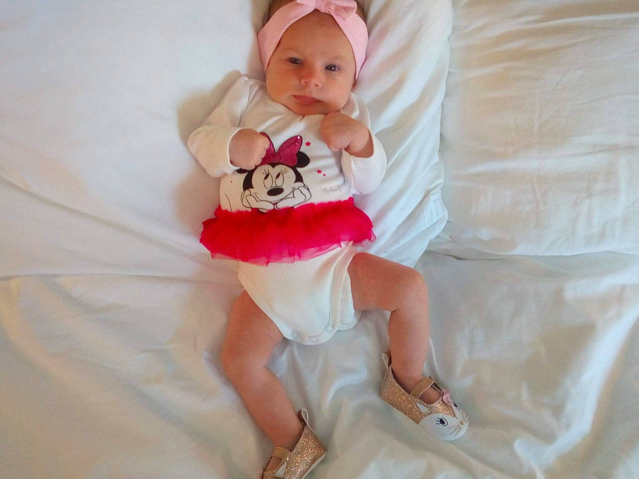 Shanel participe au concours pour gagner de l'argent avec cette photo : baby, child, costume, finger, hair_accessory, hand, headgear, leg, person, pink, smile, toddler