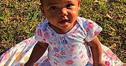 Callieann is registered to the contest to win money with this photo: animal_print, baby, blanket, child, clothing, colorful, cute, face, grass, happy, infant, leaves, nature, outdoor, playtime, portrait, purple_bow, sitting, sunlight, toddler