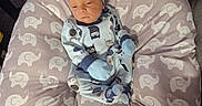 Zayne is registered to the contest to win money with this photo: baby, infant, child, portrait, lying_down, onesie, hat, mittens, owl_pattern, elephant_pattern, cushion, pacifier, indoor, home, seated, sleepy, serious_expression, blue_clothing, soft_furnishings, closeup