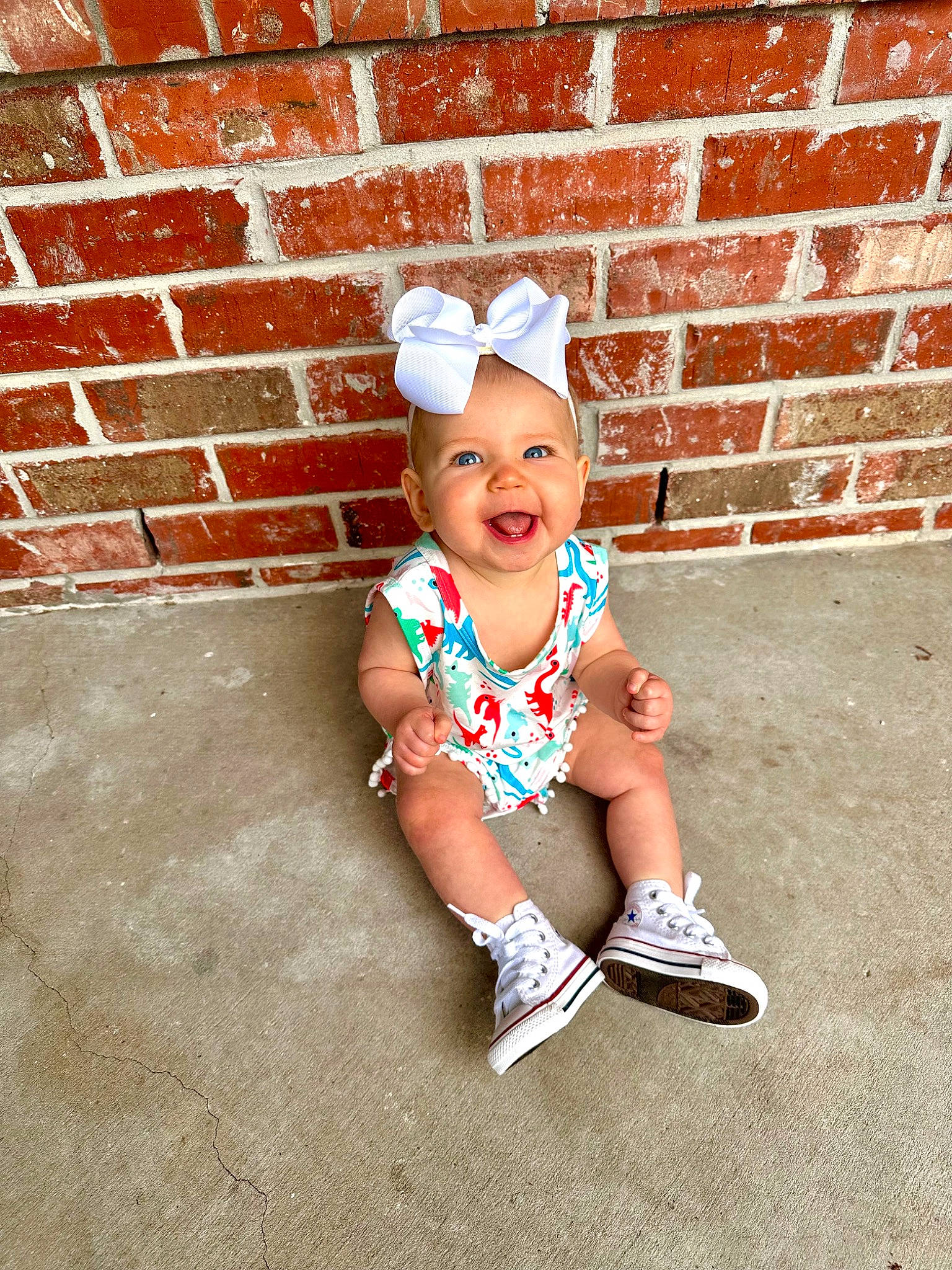 Kennedy is registered to the contest to win money with this photo: baby, baby_toddler_clothing, brick, brickwork, cap, child, costume_hat, face, fashion_accessory, grass, happy, hat, headgear, pattern, person, pink, sleeve, smile, sun_hat, t_shirt