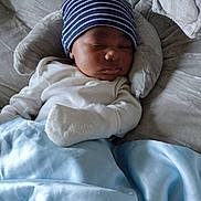 Noah is registered to the contest to win money with this photo: baby, beanie, blanket, blue, child, clothing, comfort, cozy, headwear, indoor, infant, mittens, napping, peaceful, plush, portrait, rest, sleeping, soft, white