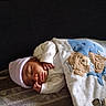 newborn, baby, sleeping, blanket, hat, elephant, teddy_bear, infant, cozy, cute, peaceful, child, clothing, bed, resting, portrait, indoors, soft, person, warm