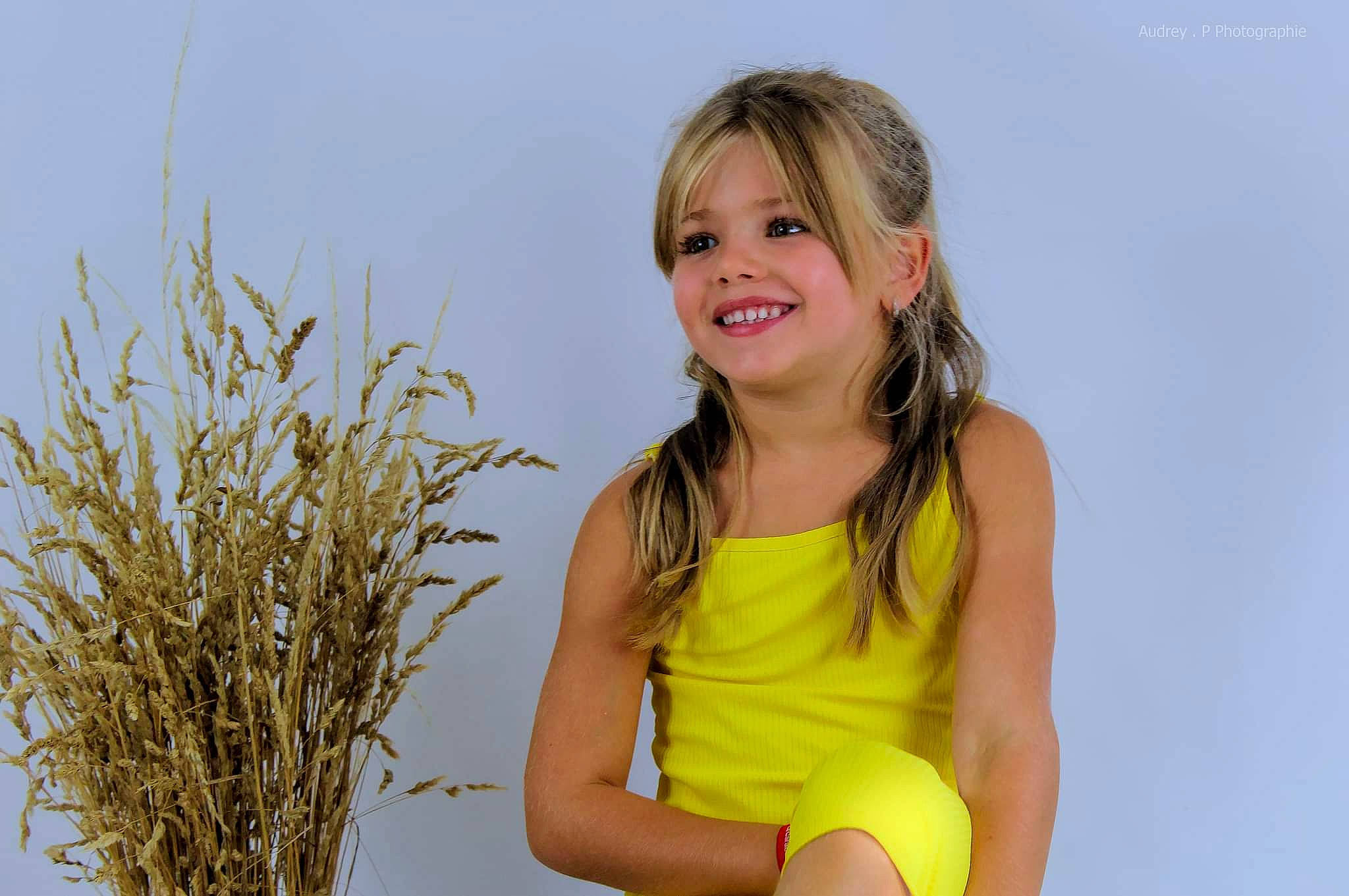 Miléna a rejoint le concours — aidez-le/la à gagner de superbes lots ! blond, brown_hair, electric_blue, event, flash_photography, fun, grass, hair, happy, human_leg, joy, long_hair, people_in_nature, person, plant, sitting, smile, surfer_hair, t_shirt, thigh