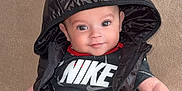 Lyandro Martinez participe au concours pour gagner de l'argent avec cette photo : baby, infant, hood, black_vest, red_pants, pacifier, couch, smile, cute, child, portrait, clothing, sitting, indoor, face, person, young, happy, casual, relaxed
