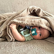 Lyandro Martinez participe au concours pour gagner de l'argent avec cette photo : baby, blanket, pacifier, infant, cozy, cute, child, soft_texture, bed, resting, wrapped, hand, face, lying_down, comfort, indoor, young_child, skin, expression, clothing