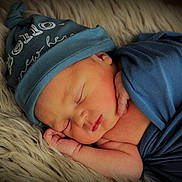 Jonah joined the competition — help win amazing prizes! newborn, baby, sleeping, blue_hat, blue_wrap, infant, soft_texture, fluffy_rug, peaceful, closeup, portrait, cute, small_hands, resting, indoors, skin, face, headwear, wrapped, cozy