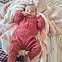baby, infant, blanket, pink, knitted_clothing, cozy, lying_down, soft_texture, bed, sleepwear, newborn, cute, child, portrait, home_interior, comfort, furniture, person, relaxing, warm_clothing