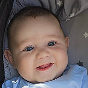 Aarón is registered to the contest to win money with this photo: baby, child, smile, face, blue_eyes, infant, cute, happy, portrait, clothing, star_pattern, cushion, close_up, person, young, baby_girl, baby_boy, soft_light, indoors, expression